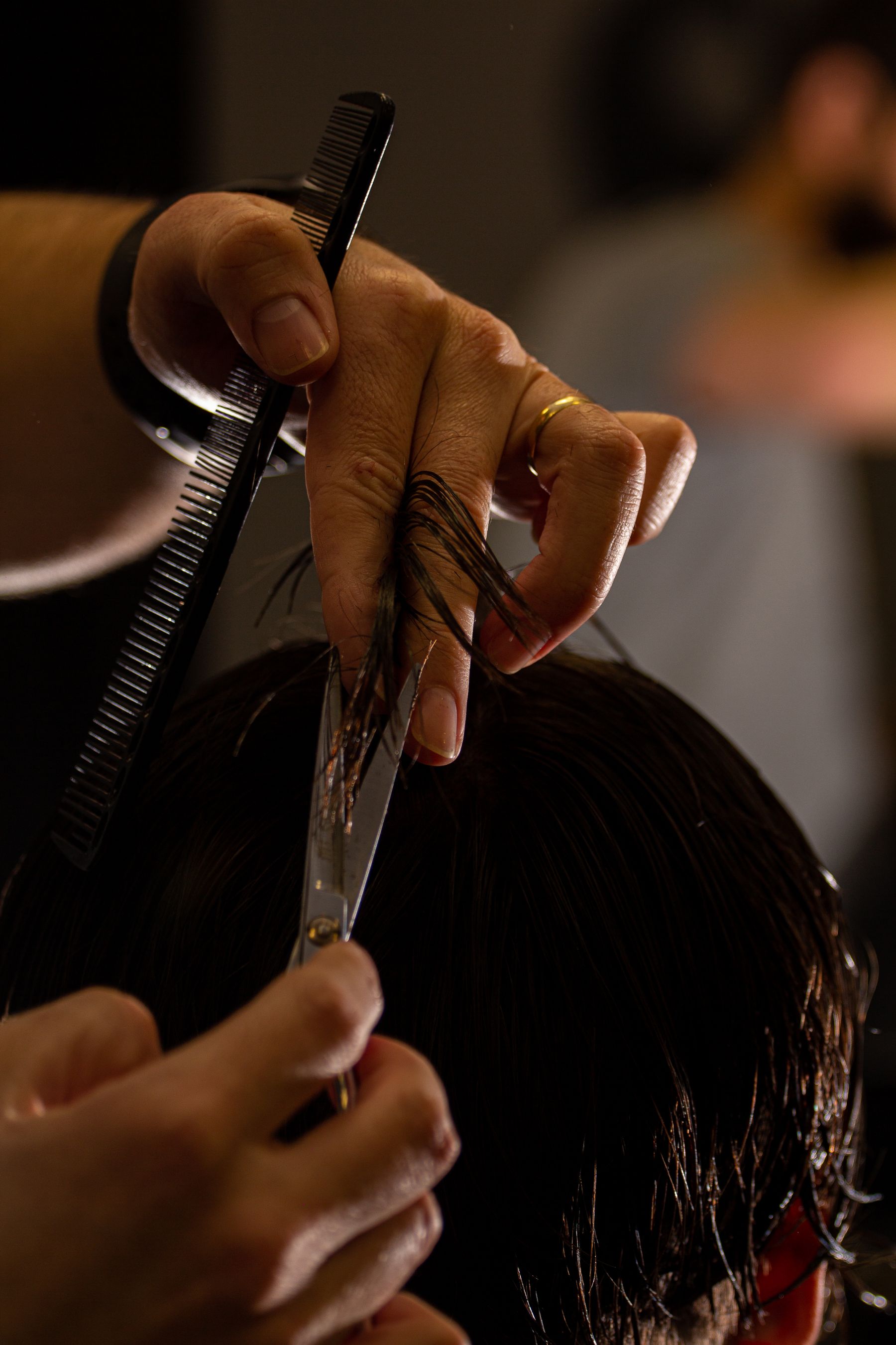 A barber working with scissors and a comb
